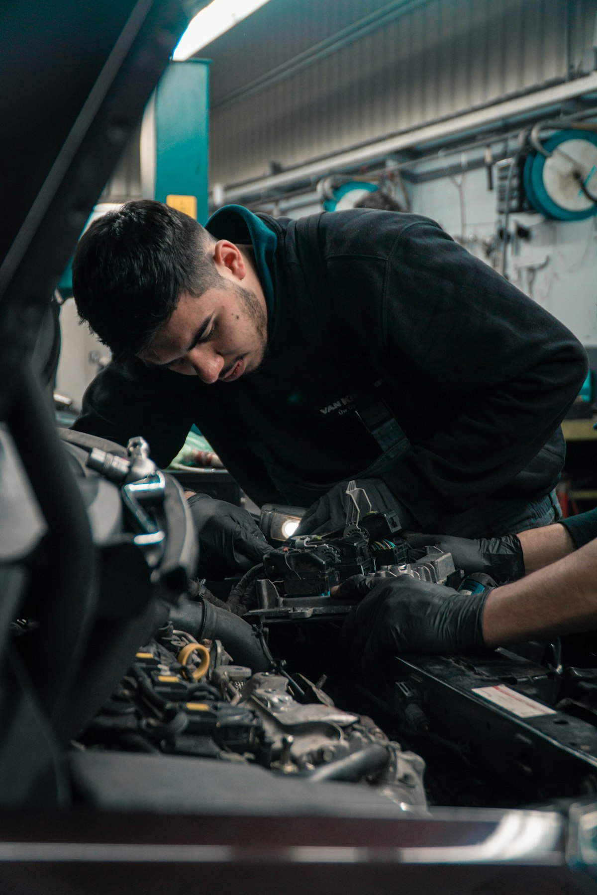 Technician performing engine repairs with inspection light